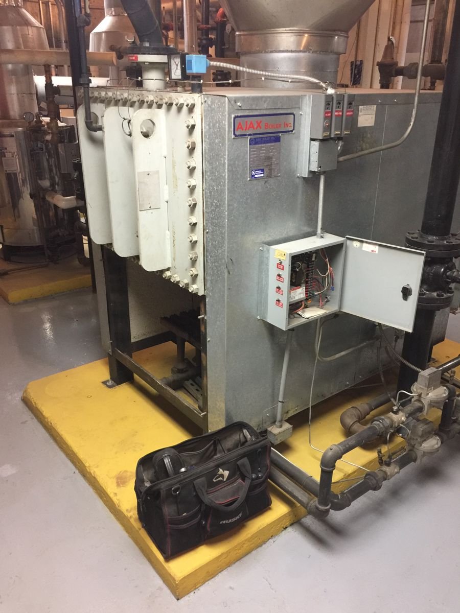 Commercial boiler with control panel on a housekeeping pad in a Central Valley mechanical room