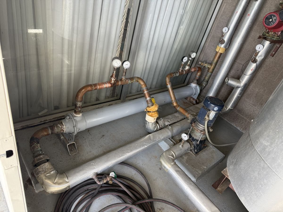 Insulated chilled-water piping, valves and gauges in a mechanical room