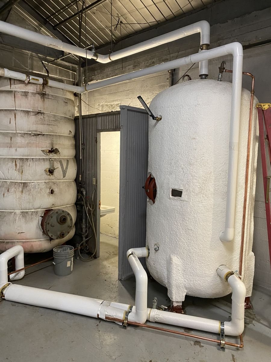 Insulated hot-water storage tanks and piping in a boiler room